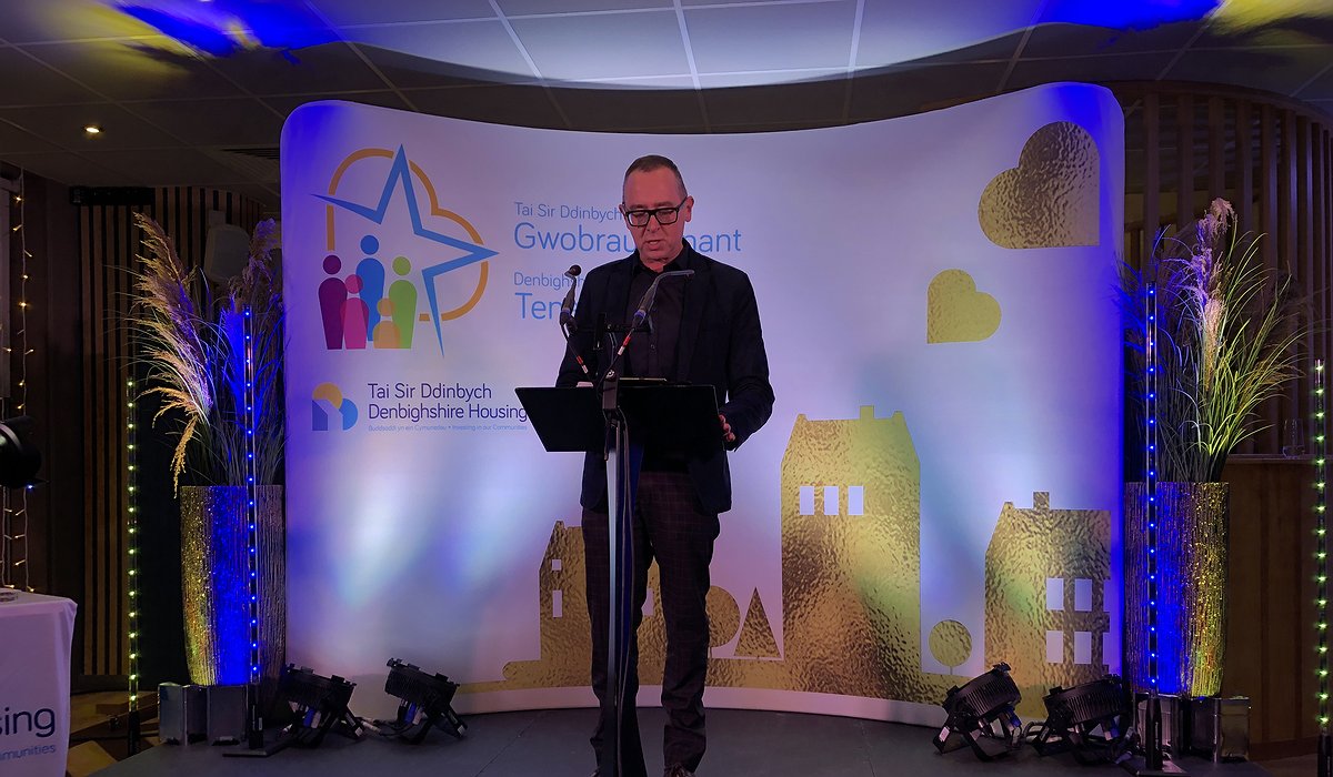 An event MC presents awards at Denbighshire Housing and Tenants Awards