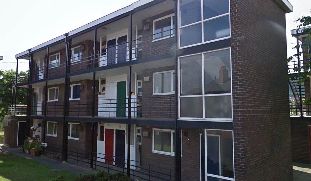Old style flats in Caradoc Road, Prestatyn. The flats have a brown exterior with railed balconies