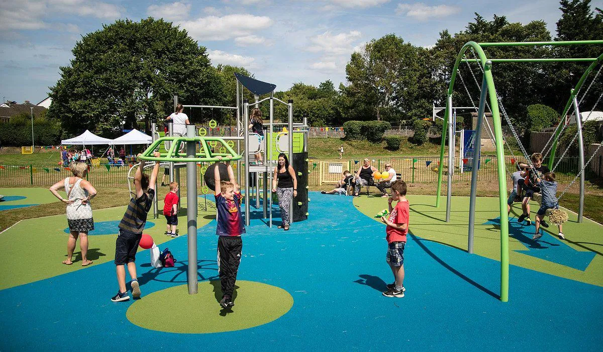 Children playing on new colourful play area equipment in Henllan