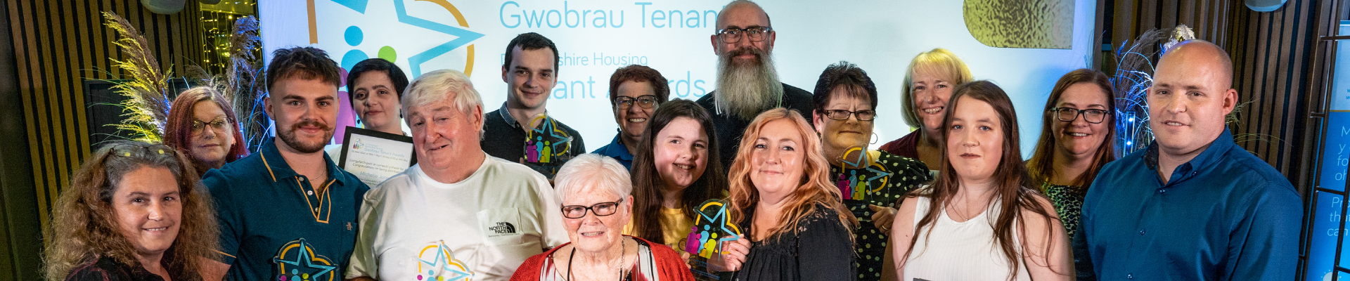 Group of people holding up awards. Various ages and genders. 