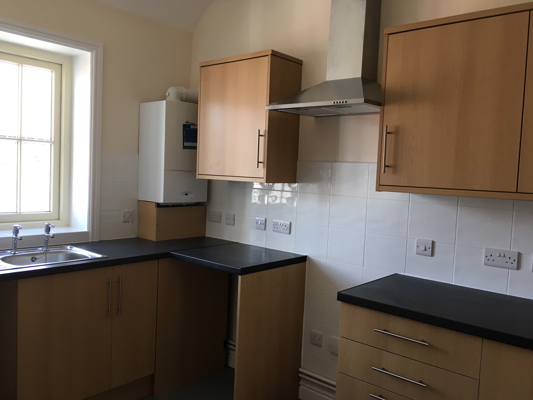 A new kitchen with wood effect doors and black worktops