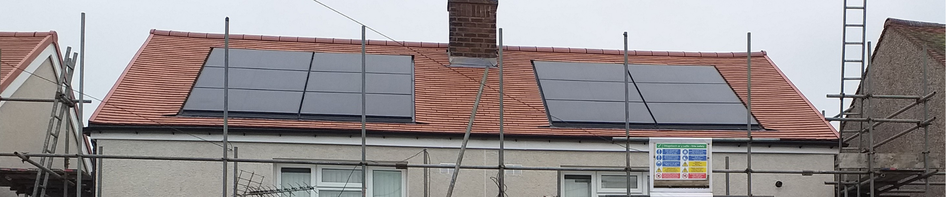 Red tiled roof with solar panels on. 