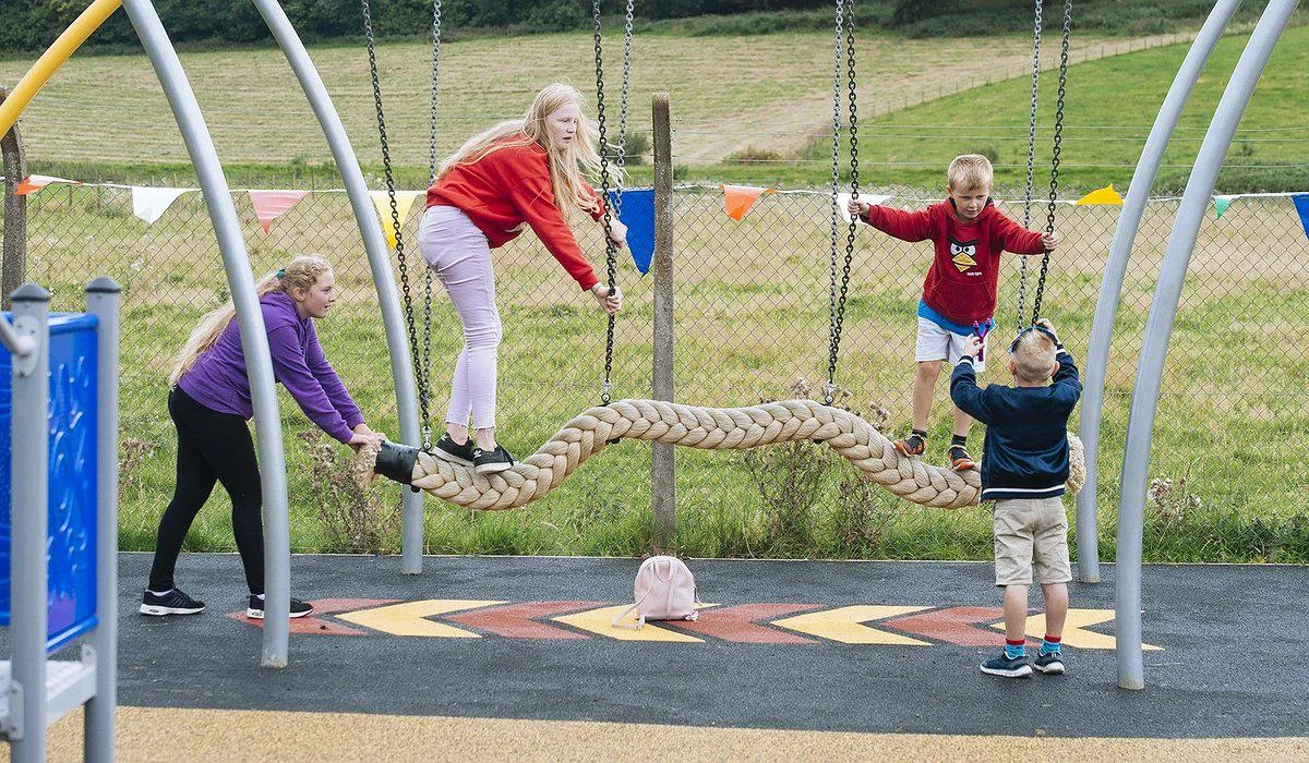 Four children playing on a rope bridge in Ruthin