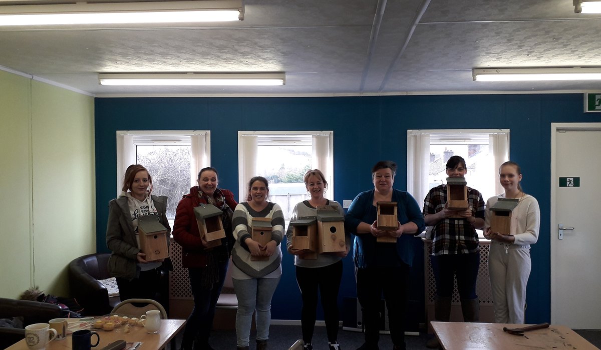 A small group of women standing in Pengwern Community Centre in Llangollen showing their bird box building.