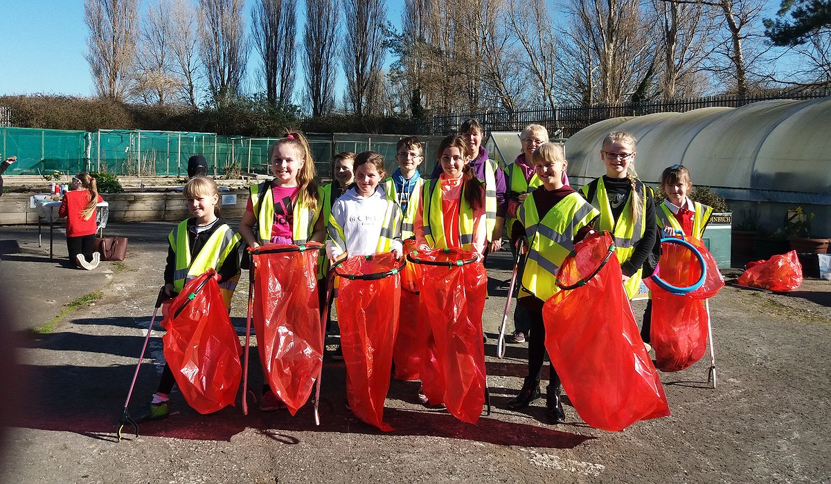 A group of children taking part in litter picking at Morfa Gateway as part of the Nature for Health project