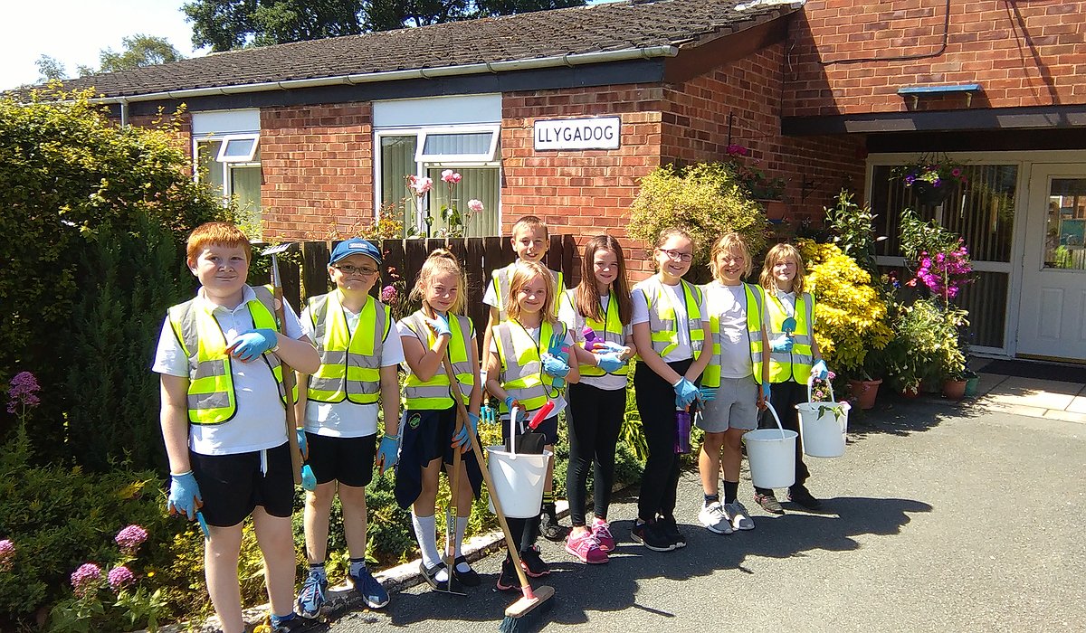 A group of young school children learning to keep gardens tidy at Llygadog Community Centre