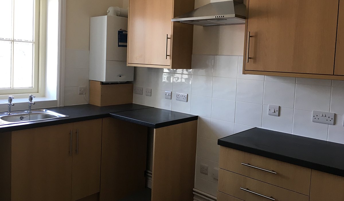 A new kitchen with wood effect doors and black worktops.
